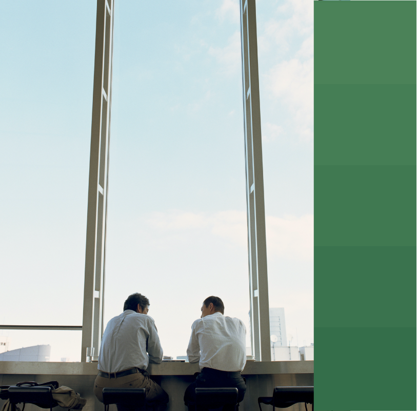 Two male coworkers speaking by a window