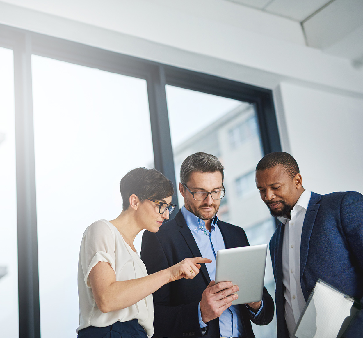 Shot of a team of colleagues using a digital tablet together at work